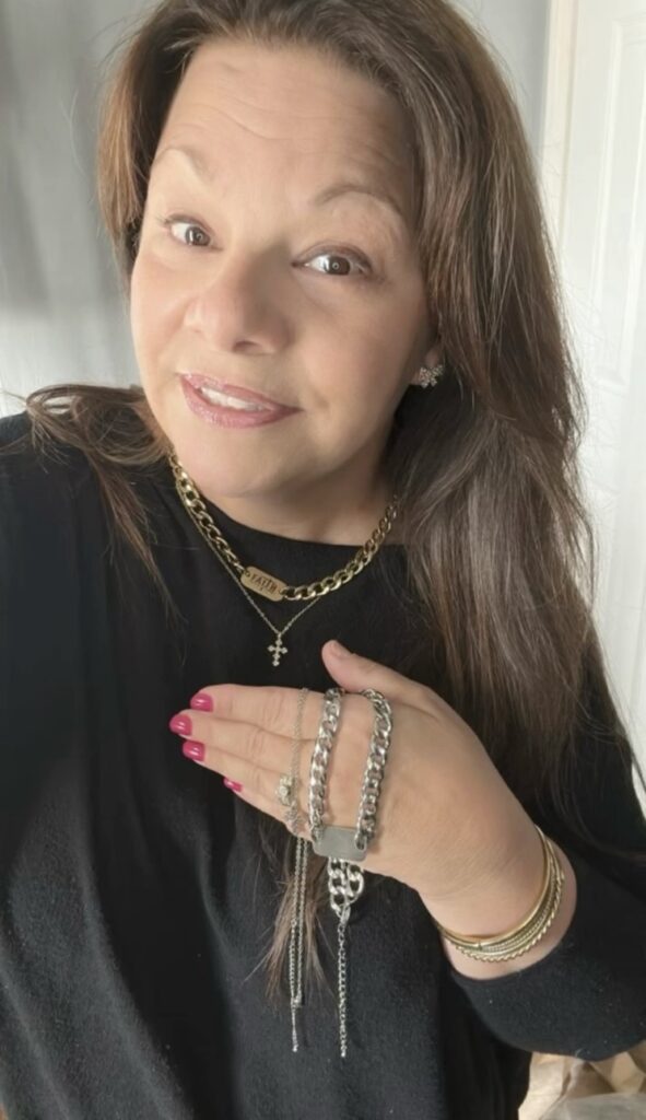 “Woman smiling while holding jewelry at home jewelry party”