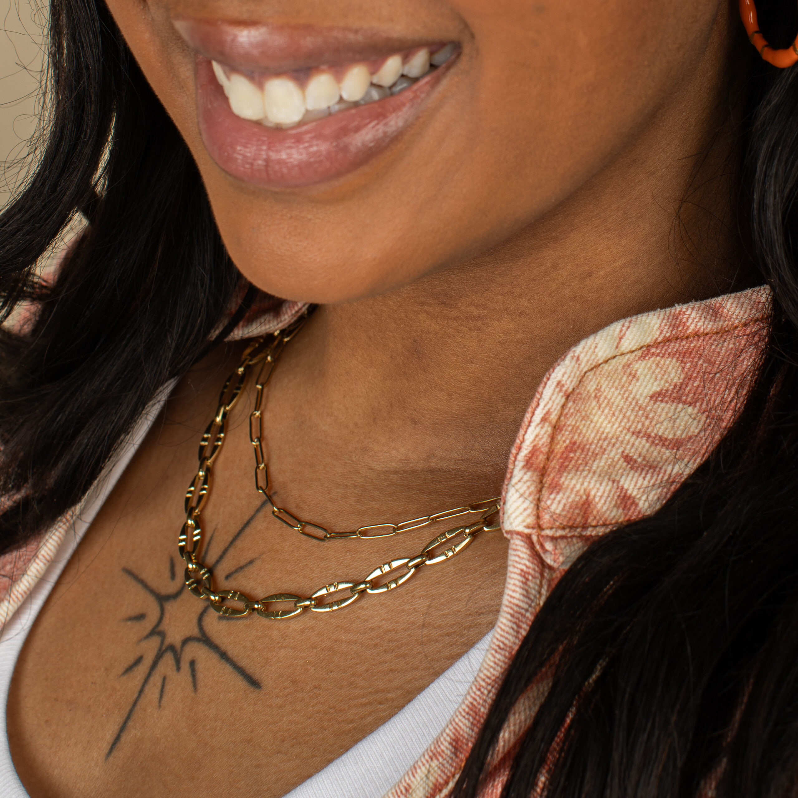 Layered gold permanent necklaces and paperclip chain jewelry worn by model